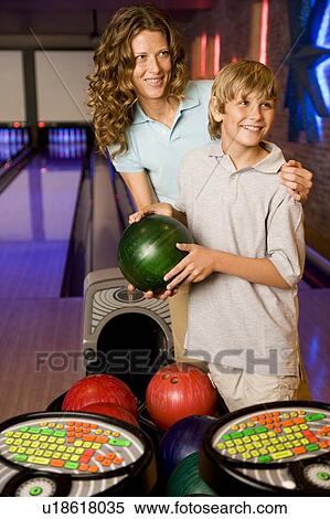 Mother and son in a bowling alley, holding green bowling ball View Large Photo Image Stock Photography - Mother and son in a bowling alley, holding green bowling ball. Fotosearch