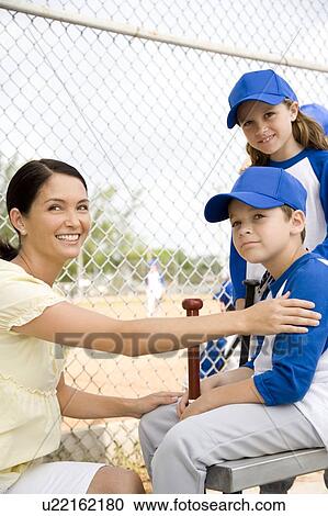 Stock Image - Mother congratulating son at little league baseball game. Fotosearch