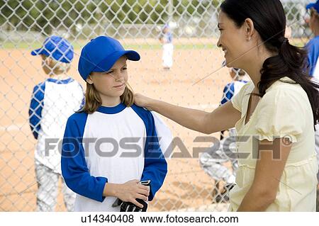 Mother encouraging daughter at little league baseball game View Large Photo Image Stock Photo - Mother encouraging daughter at little league baseball game. Fotosearch