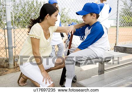 Stock Photography - Mother encouraging son at little league baseball game. Fotosearch