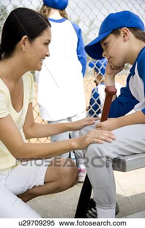 Stock Photography - Mother encouraging son at little league baseball game. Fotosearch