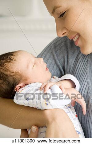 Stock Image - Mother holding her young baby. Fotosearch