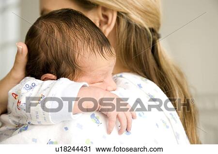 Stock Image - Mother holding her young baby. Fotosearch