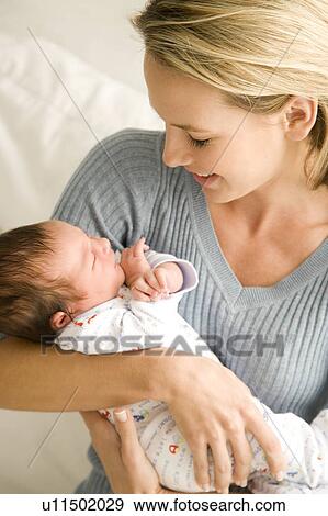 Mother holding her young baby View Large Photo Image Stock Photo - Mother holding her young baby. Fotosearch