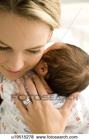 Mother holding her young baby View Large Photo Image Stock Photo - Mother holding her young baby. Fotosearch