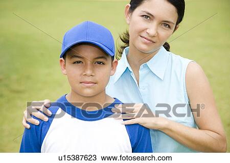 Mother poses with her son after a baseball game View Large Photo Image Stock Image - Mother poses with her son after a baseball game. Fotosearch