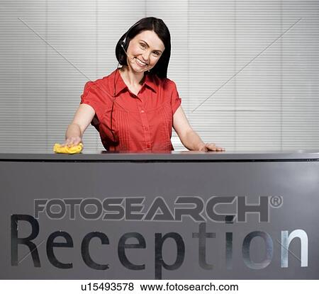 Stock Photo - Office receptionist in a red blouse, smiling. Fotosearch