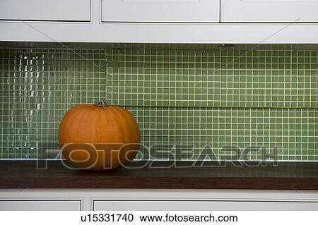 Stock Image - Orange Hallowe'en pumpkin on a kitchen counter. Fotosearch