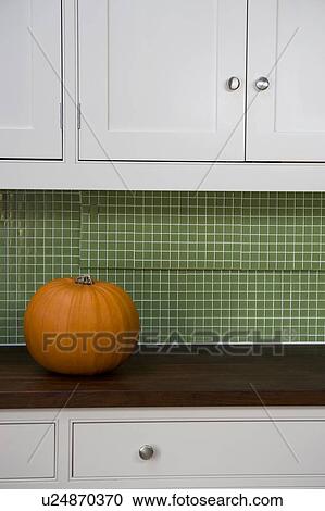Stock Image - Orange Hallowe'en pumpkin on a kitchen counter. Fotosearch