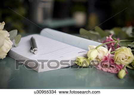 Order book and pen lying on the counter of a florist's shop View Large Photo Image Picture - Order book and pen lying on the counter of a florist's shop. Fotosearch
