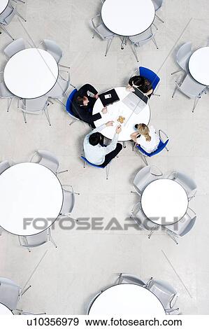 Stock Photo - Overhead view of informal business meeting at table of staff canteen. Fotosearch