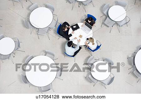 Overhead view of informal business meeting at table of staff canteen View Large Photo Image Stock Photo - Overhead view of informal business meeting at table of staff canteen. Fotosearch
