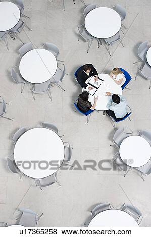 Stock Photo - Overhead view of informal business meeting at table of staff canteen. Fotosearch