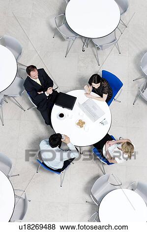 Stock Photo - Overhead view of informal business meeting at table of staff canteen. Fotosearch
