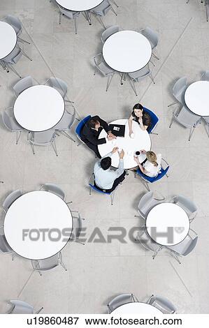 Stock Photo - Overhead view of informal business meeting at table of staff canteen. Fotosearch