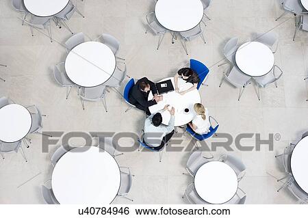 Overhead view of informal business meeting at table of staff canteen View Large Photo Image Stock Photograph - Overhead view of informal business meeting at table of staff canteen. Fotosearch
