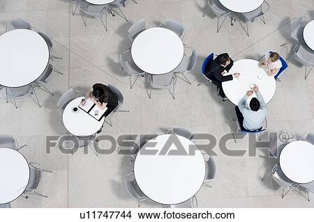 Overhead view of office workers at tables in the staff canteen View Large Photo Image Picture - Overhead view of office workers at tables in the staff canteen. Fotosearch