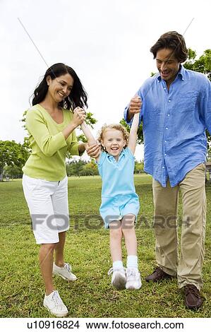 parents playing with their daughter in the park View Large Photo Image Picture - parents playing with their daughter in the park. Fotosearch