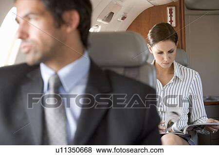 Stock Photo - Passengers relaxing on a flight. Fotosearch