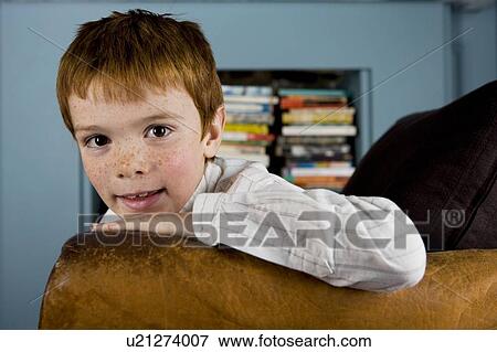 Stock Photo - portrait boy leaning on arm of sofa. Fotosearch