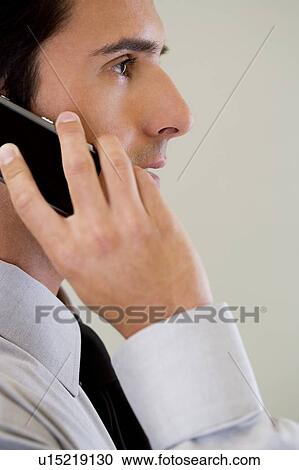 Stock Image - Portrait of a businessman using a mobile phone. Fotosearch