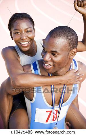 Stock Image - Portrait of a female and athletes celebrating their win. Fotosearch