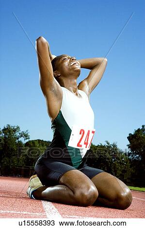 Stock Image - Portrait of a female athlete celebrating her win. Fotosearch