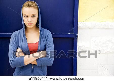 Portrait of a girl leaning against a blue painted wall View Large Photo Image Stock Image - Portrait of a girl leaning against a blue painted wall. Fotosearch