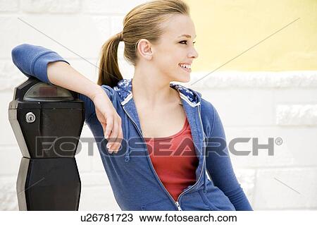 Stock Image - Portrait of a girl leaning against a traffic meter. Fotosearch