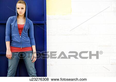 Portrait of a girl leaning against a blue painted wall View Large Photo Image Stock Photo - Portrait of a girl leaning against a blue painted wall. Fotosearch
