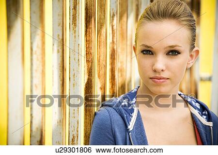 Stock Photograph - Portrait of a girl leaning against railing bars. Fotosearch