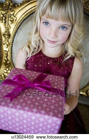 Stock Photo - Portrait of a little girl holding birthday presents. Fotosearch