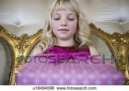 Stock Photo - Portrait of a little girl holding birthday presents. Fotosearch