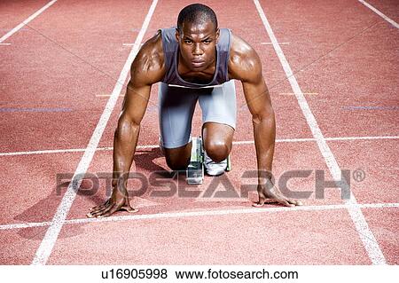 Stock Photo - Portrait of a male athlete in the starting blocks. Fotosearch