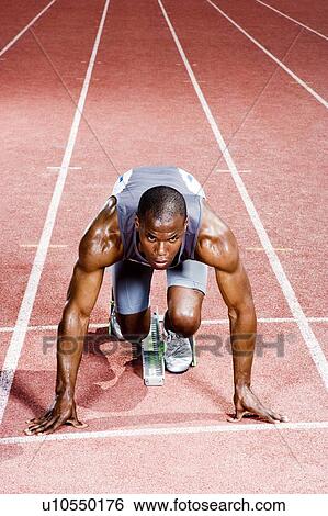 Stock Photograph - Portrait of a male athlete in the starting blocks. Fotosearch