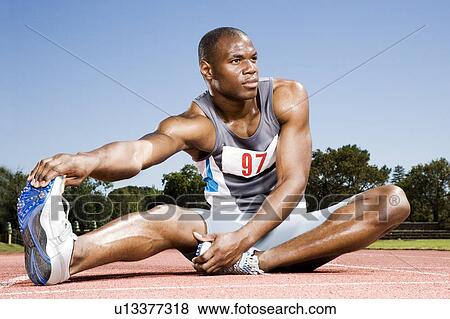 Portrait of a male athlete warming up and stretching View Large Photo Image Stock Photo - Portrait of a male athlete warming up and stretching. Fotosearch