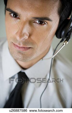 Portrait of a man using a call centre headset View Large Photo Image Stock Photograph - Portrait of a man using a call centre headset. Fotosearch
