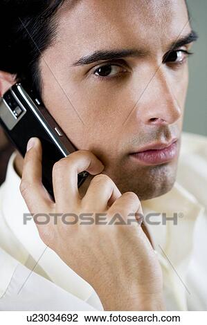 Stock Image - Portrait of a man using a cellphone. Fotosearch