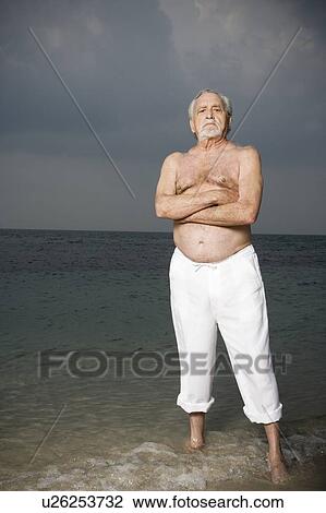 Portrait of a senior man standing in the sea View Large Photo Image Stock Image - Portrait of a senior man standing in the sea. Fotosearch