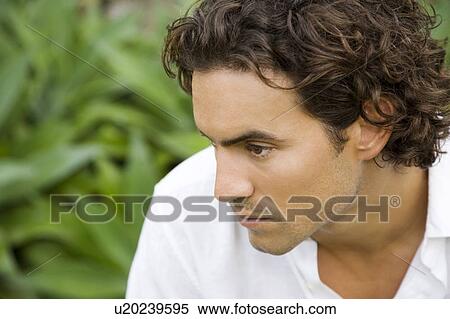 Stock Photography - Portrait of a serious looking man in a tropical garden. . Fotosearch