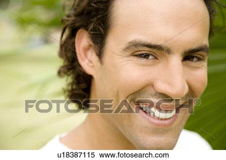 Stock Photography - Portrait of a smiling adult man in a tropical garden. . Fotosearch