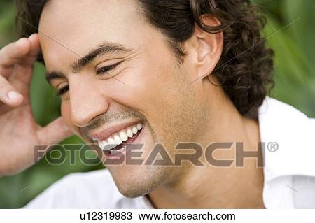 Stock Image - Portrait of a smiling man in a tropical garden. . Fotosearch