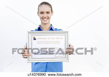 Stock Image - Portrait of a supermarket assistant with an Employee of the Month certificate. Fotosearch