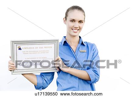 Stock Image - Portrait of a supermarket assistant with an Employee of the Month certificate. Fotosearch