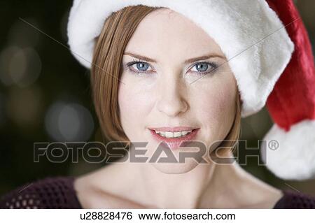 Stock Photograph - Portrait of a woman wearing Santa's hat. Fotosearch