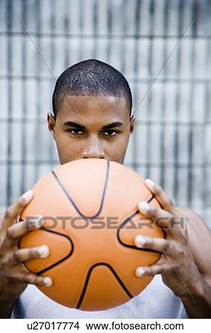 Picture - Portrait of a young African American man holding a basketball. . Fotosearch