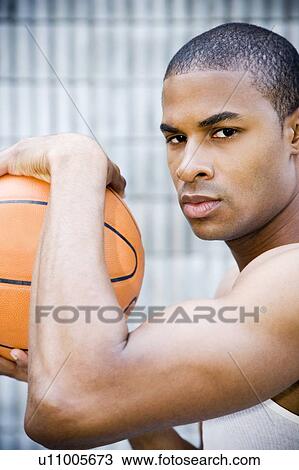 Portrait of a young African American man holding a basketball. View Large Photo Image Stock Image - Portrait of a young African American man holding a basketball. . Fotosearch