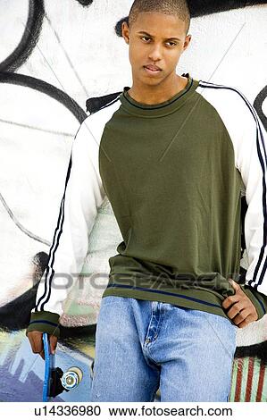 Portrait of a young African American man in front of a graffiti covered wall View Large Photo Image Stock Image - Portrait of a young African American man in front of a graffiti covered wall. Fotosearch