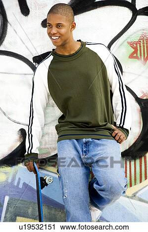 Portrait of a young African American man in front of a graffiti covered wall View Large Photo Image Stock Image - Portrait of a young African American man in front of a graffiti covered wall. Fotosearch