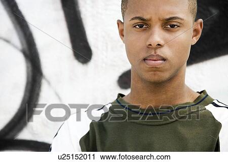 Portrait of a young African American man in front of a graffiti covered wall View Large Photo Image Stock Image - Portrait of a young African American man in front of a graffiti covered wall. Fotosearch